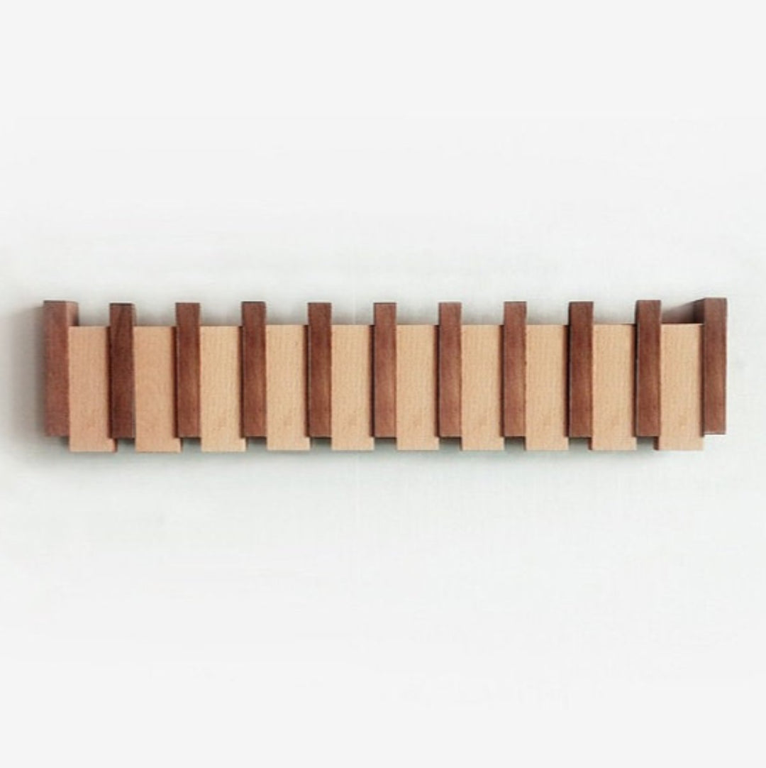 Handgemaakte houten kapstok in piano design met elegante, pianotoetsen uitstraling. Perfect voor stijlvolle jassenopslag.