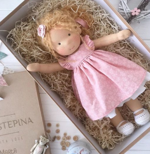Waldorf speelpop in kinderhanden, klaar voor nieuwe avonturen en educatief spel.