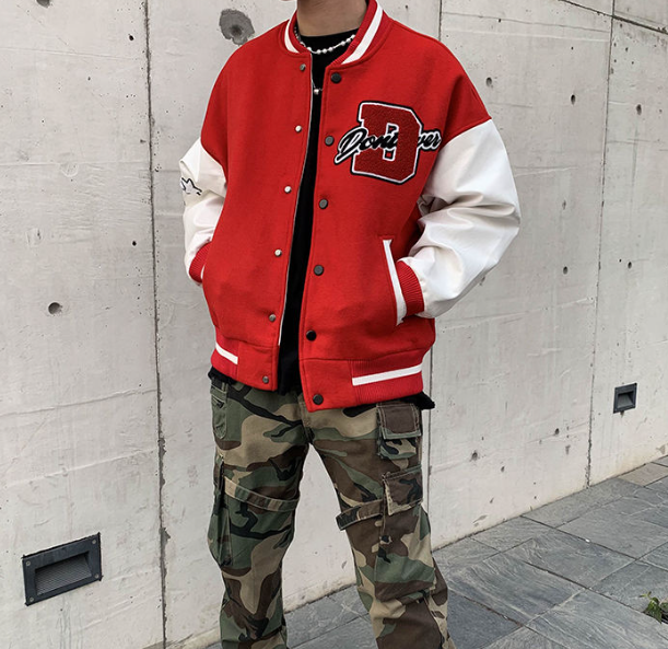 Model draagt zwart American Style heren baseballjack, gecombineerd met jeans voor casual look.