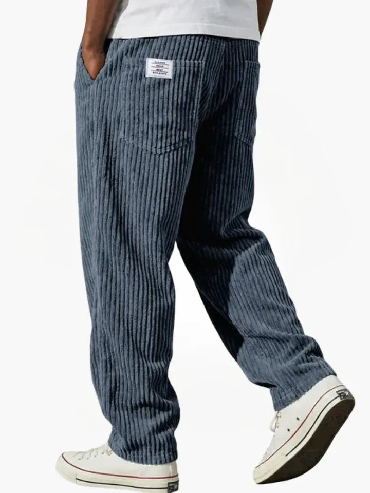 Grijze heren corduroy broek, comfortabele losse pasvorm en elastische tailleband, essentiële herenmode.