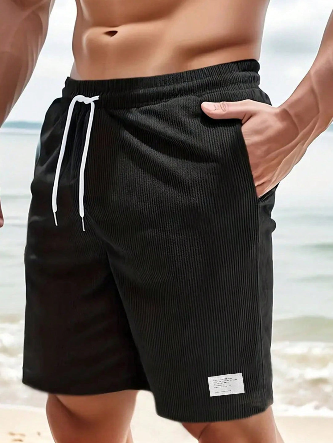Man draagt heren shorts, relaxed fit, met elastische taille en koordjes. Perfect voor casual herenmode.