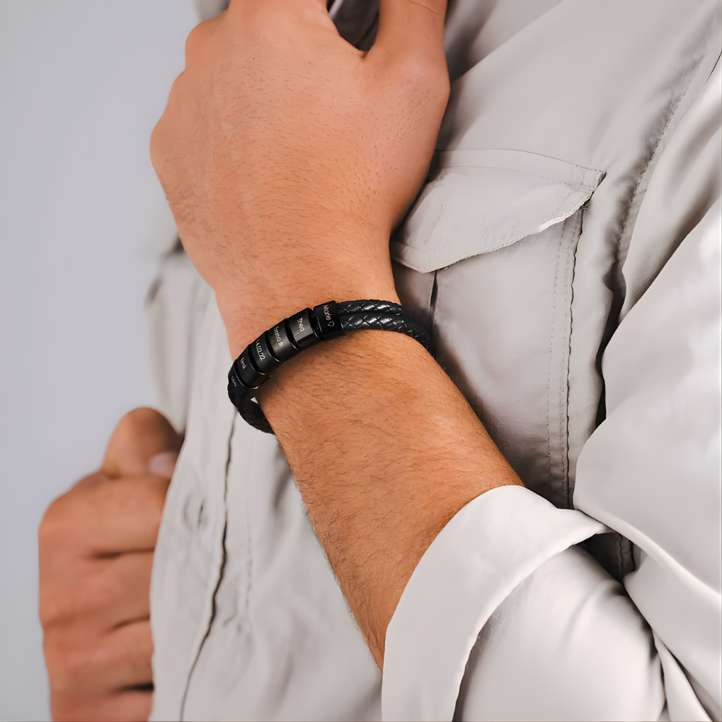 Close-up van personaliseerbare herenarmband met zwarte kralen en fijne gravure op edelstaal, perfect cadeau.