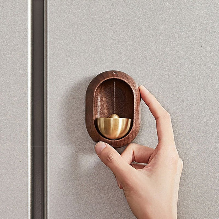 Rustgevende houten deurgong met messing accenten; perfect als gastvrije deurbel en unieke huisdecoratie.