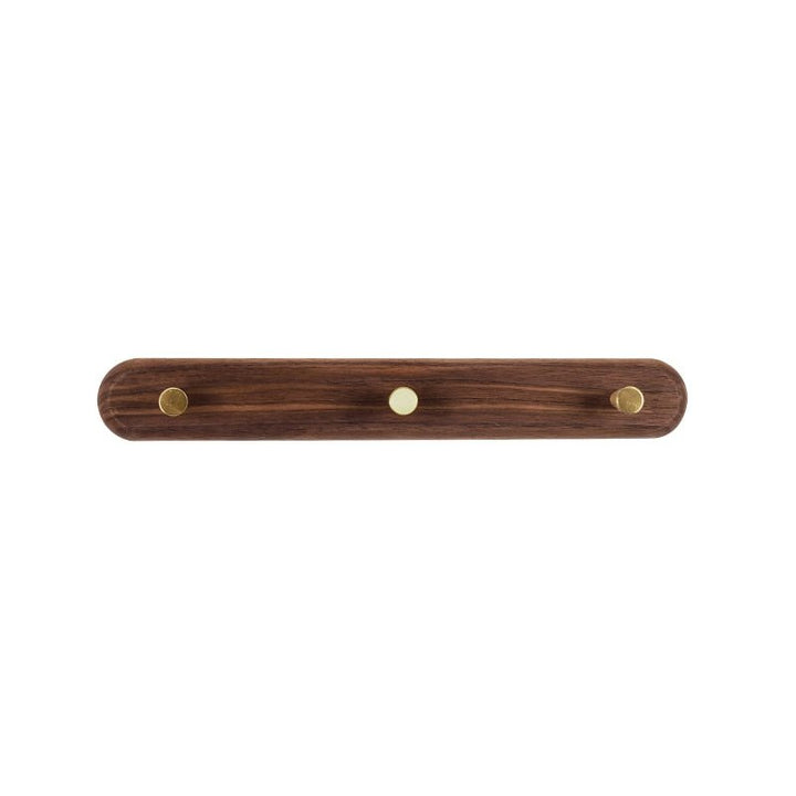 Strakke houten wandkapstok met minimalistische messing haken, een functioneel designstatement.