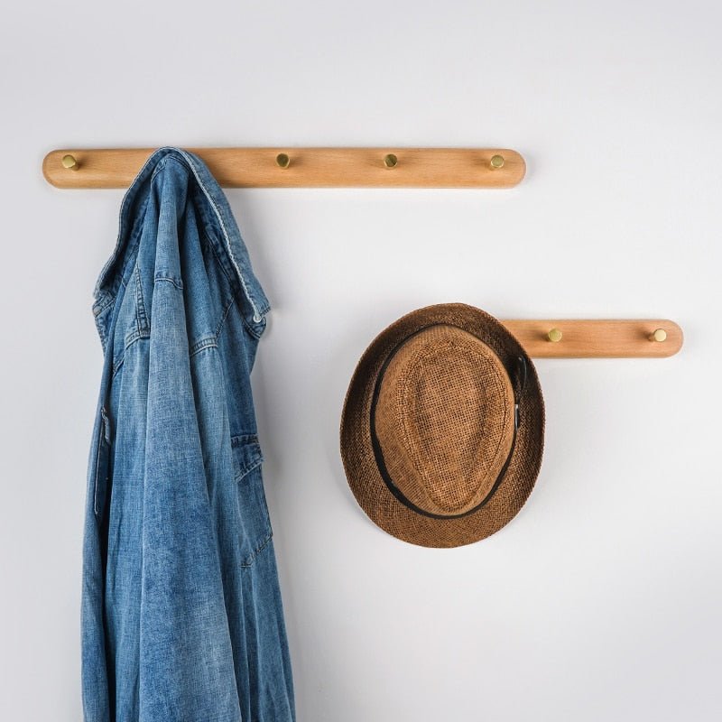 Moderne LignaHook wandkapstok: massief hout en elegante messing haken voor een opgeruimde hal.