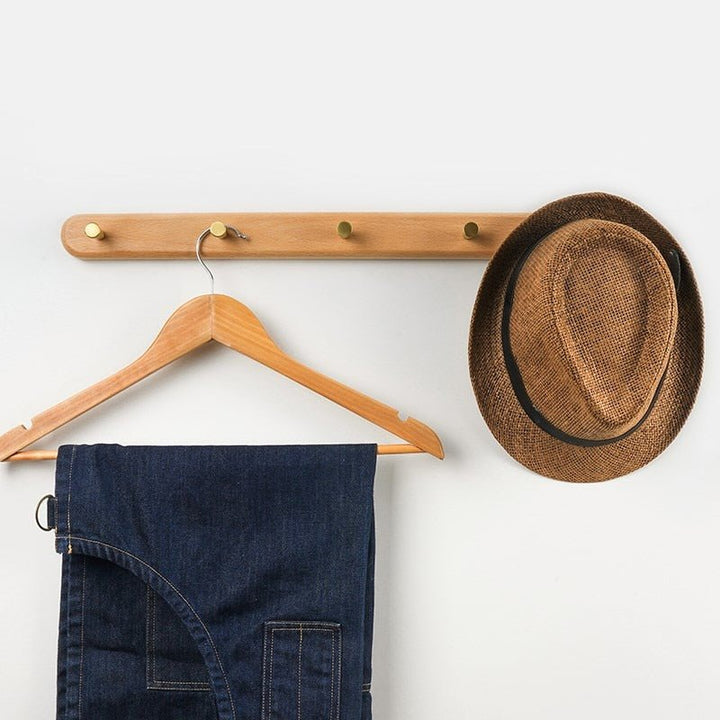 Design wandkapstok van hout met messing haken, een chique woonaccessoire voor elke kamer.