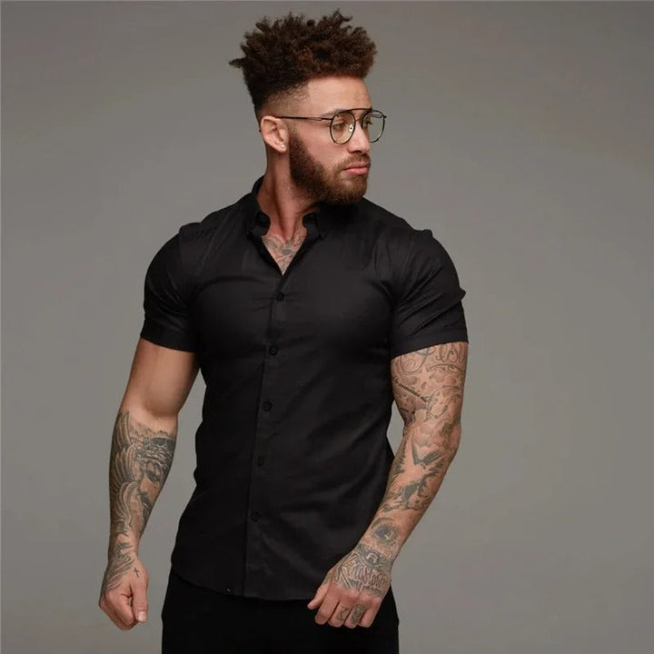 Een man met het blauwe korte mouwen overhemd, perfect voor een smart casual outfit tijdens warm weer.