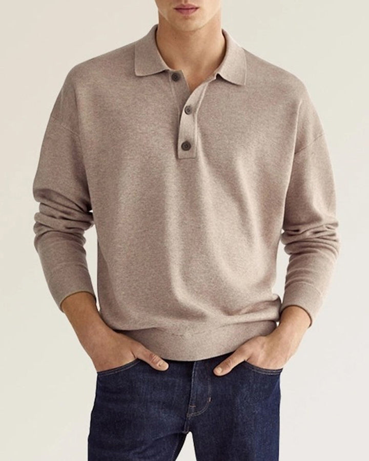 Man draagt een stijlvolle beige polo met lange mouwen en knoopsluiting