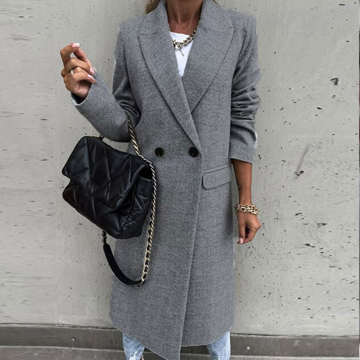 Tijdloze lange dames manteljas met knopen. Essentiële tussenjas voor een klassieke fashion statement.