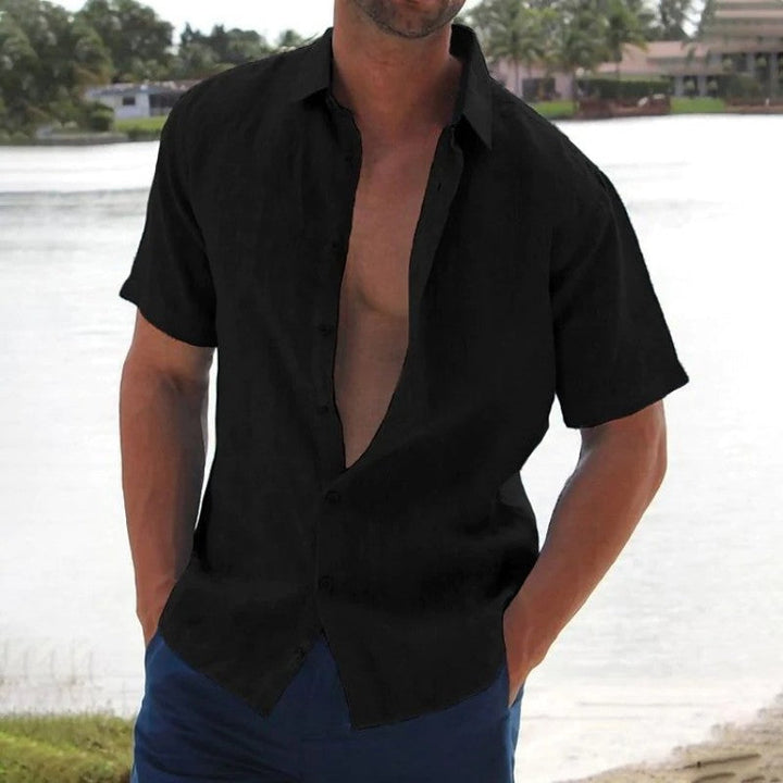 Man draagt effen heren overhemd met korte mouwen, perfect voor casual zomerse mode en stijlvol comfort.