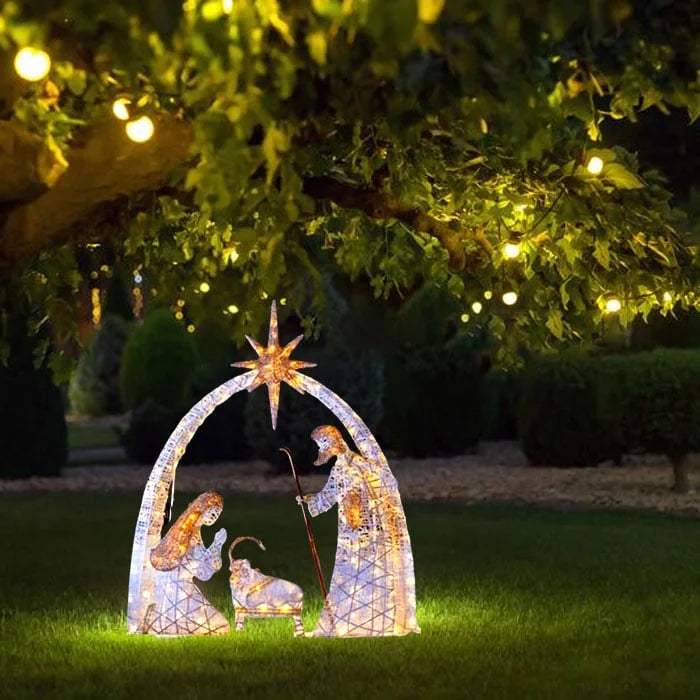 Detailopname van het LED-verlichte Heilige Familie kerst tuinornament in een winterse setting.