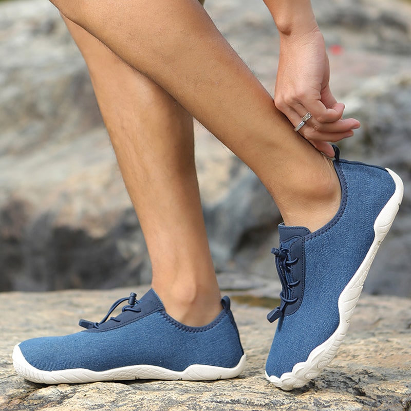 Persoon wandelt in natuur met Leonis unisex barefoot sneakers, genietend van natuurlijke bewegingsvrijheid.