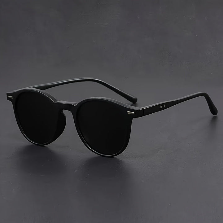 Moderne heren zonnebril met rond montuur in een elegante zwarte afwerking, voor de modebewuste man.