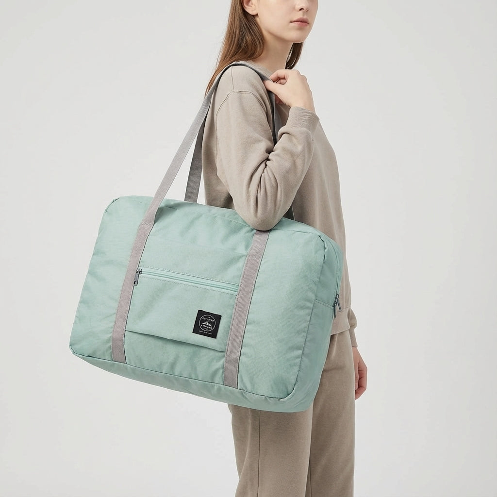 FoldLite lichtgewicht reistas gedragen door reiziger, toont gemak als handbagage voor vlieg- en treinreizen.