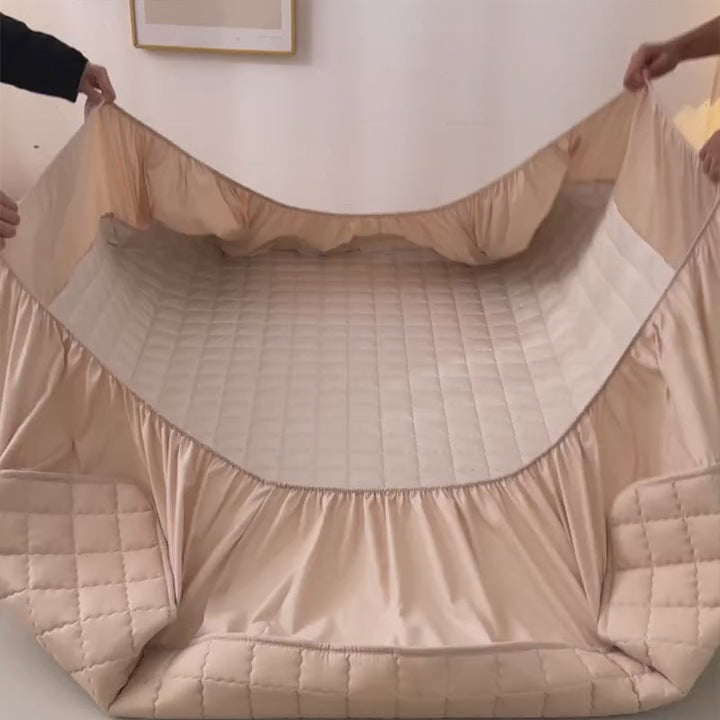 Witte waterdichte matrasbeschermer op een matras; verbetert beddengoed en slaapcomfort.