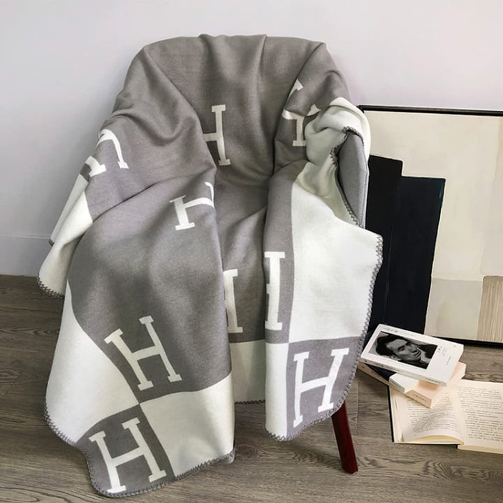 Premium woonaccessoire: een warm en zacht plaid van wol en kasjmier op een bed.