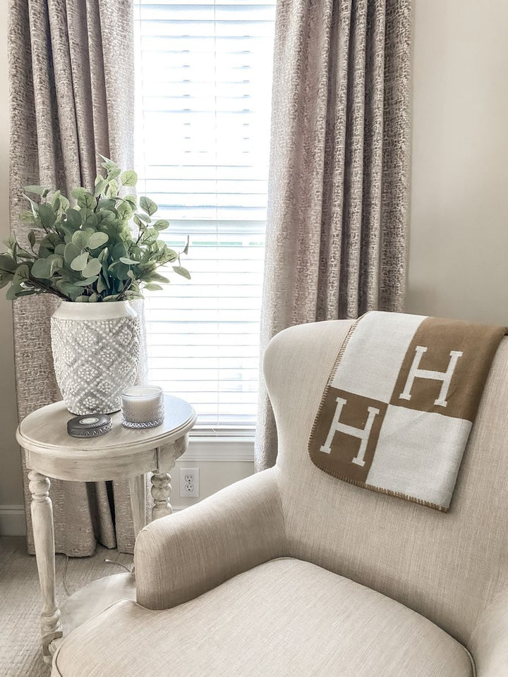 Gevouwen luxe plaid van wol en kasjmier, klaar om warmte en comfort te bieden.