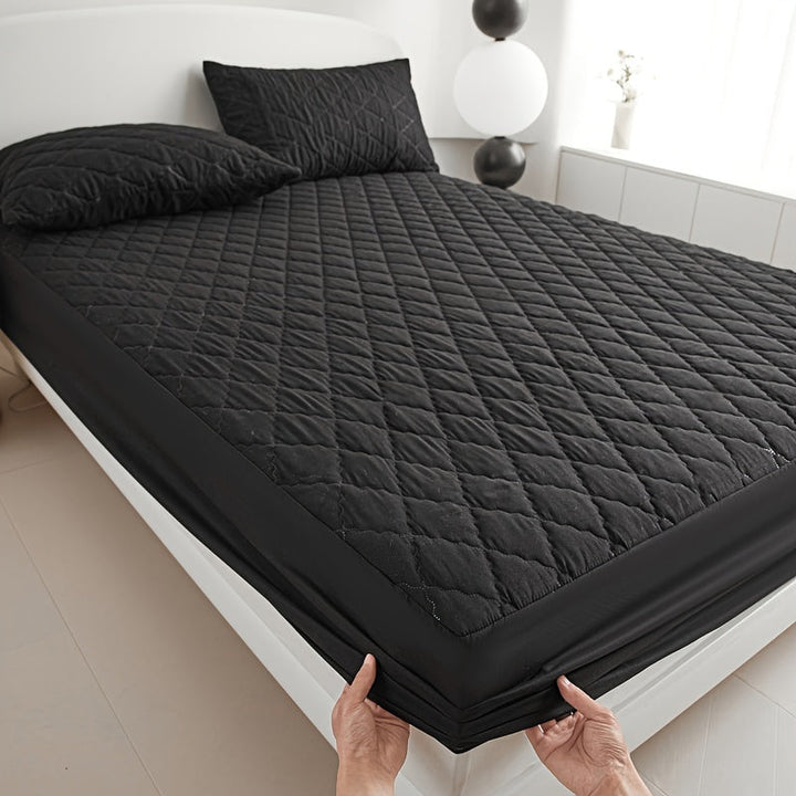 Witte waterdichte matrasbeschermer, gewatteerd en ademend, perfect op een bed voor matrasbescherming.