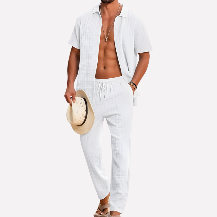 Man draagt comfortabele tweedelige zomeroutfit op het strand. Ideale herenkleding voor relaxte vakantie.