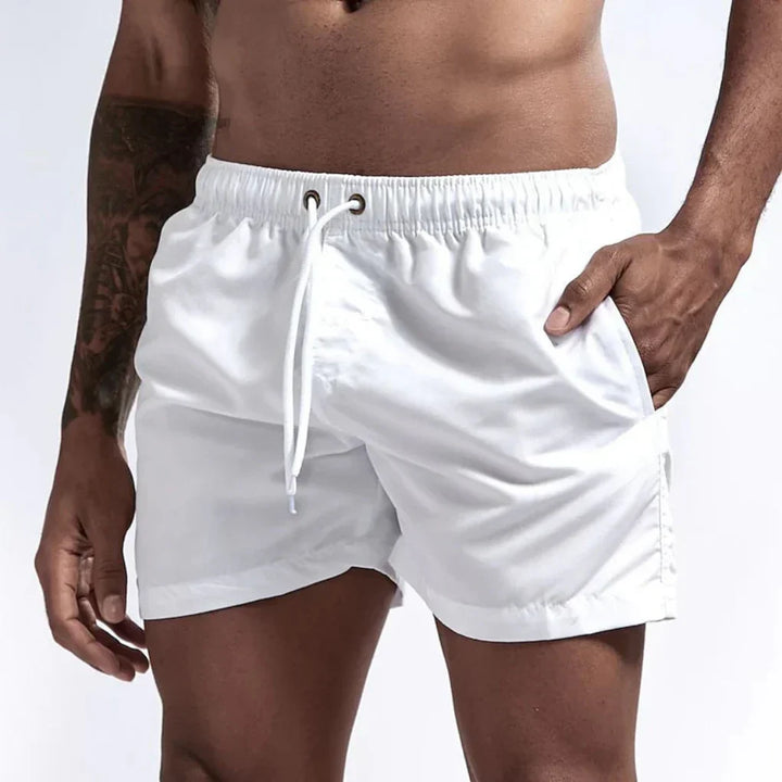 Witte sneldrogende zwemshort voor heren aan het strand