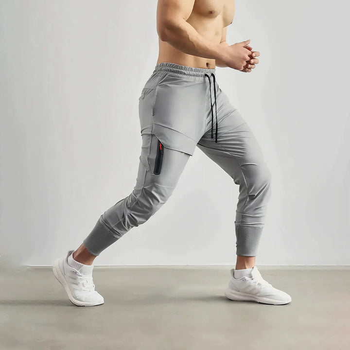 Man draagt grijze sport joggers van de zijkant tijdens het sporten