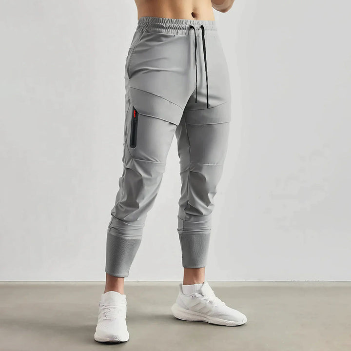 Achterkant van de marineblauwe sportjoggers met flatlock naden tegen schuren.