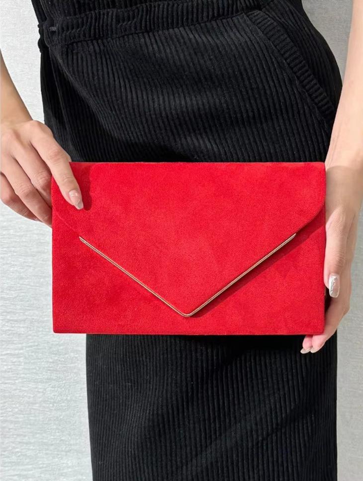 Vrouw houdt rode envelop handtas vast