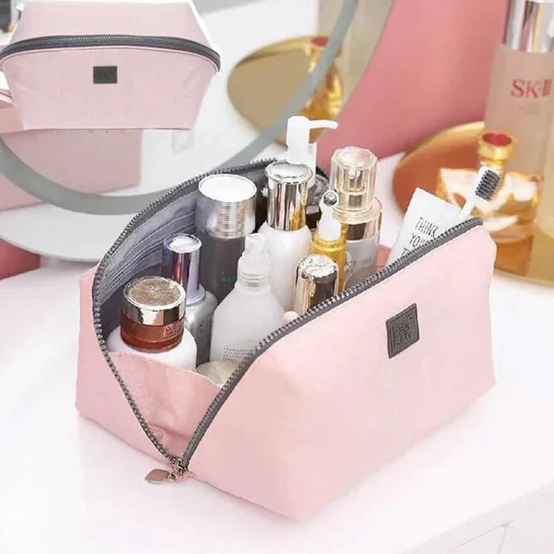 Open roze Packify make-up organizer tas toont ruime compartimenten voor reizen en efficiënt opbergen.