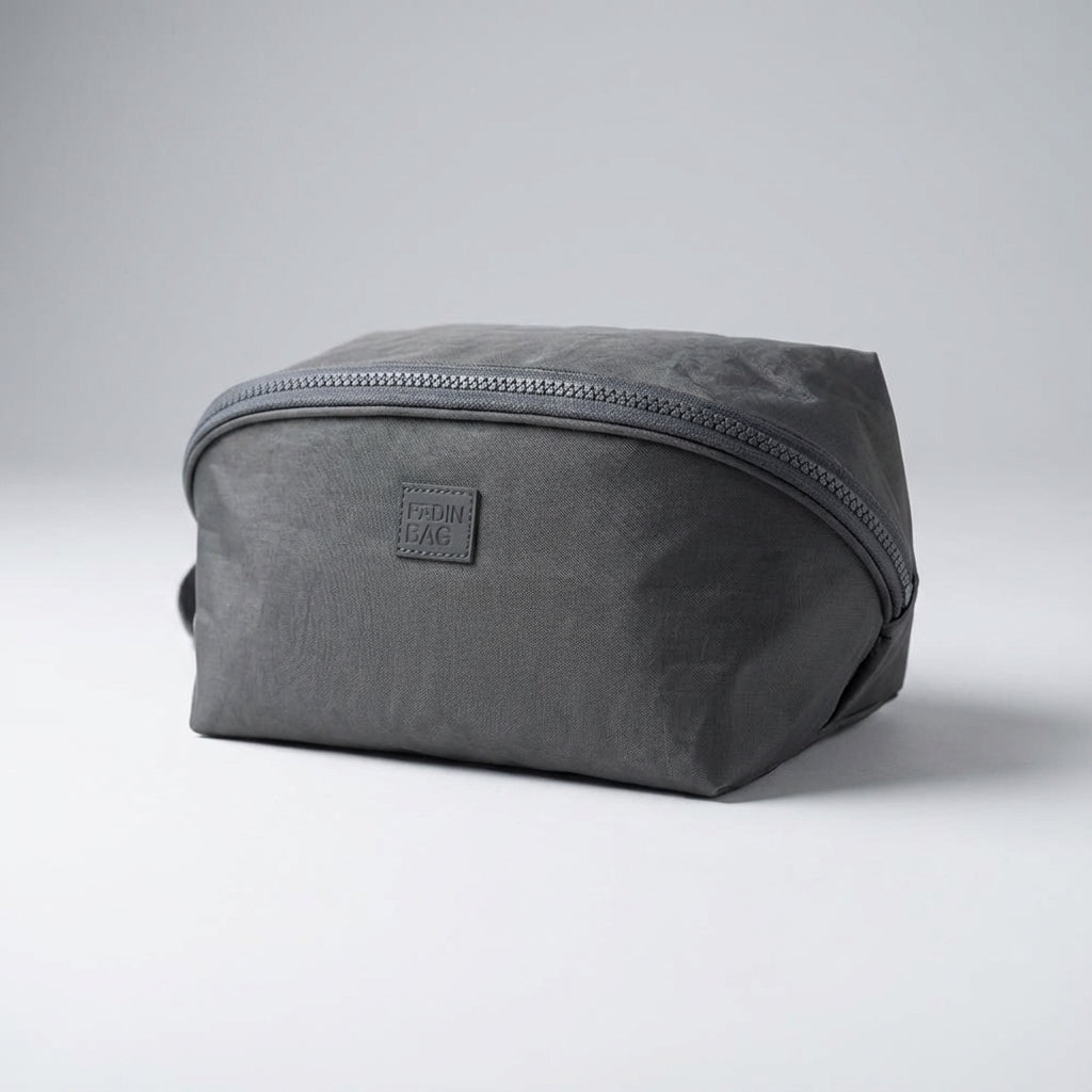 Stijlvolle grijze Packify toilettas voor reizen, compact design, handig voor make-up, toiletartikelen en persoonlijke items.
