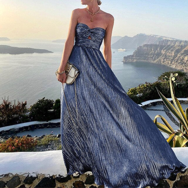 Mouwloze roze maxi zomerjurk met diepe v-hals en taille-accent, ideaal voor een zomerse gelegenheid.