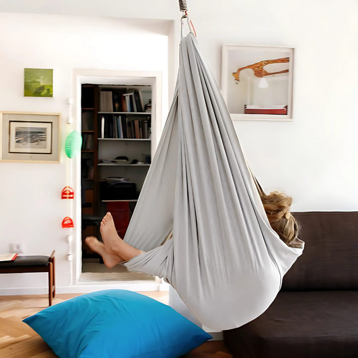Comfortabele sensorische hangmat schommel in kinderkamer. Biedt geborgenheid en ontspanning, ideaal voor binnen spelen.