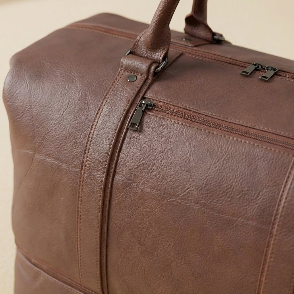 Unisex zwarte leren schoudertas als praktische duffelbag, ideaal voor weekendreizen en stijlvol.