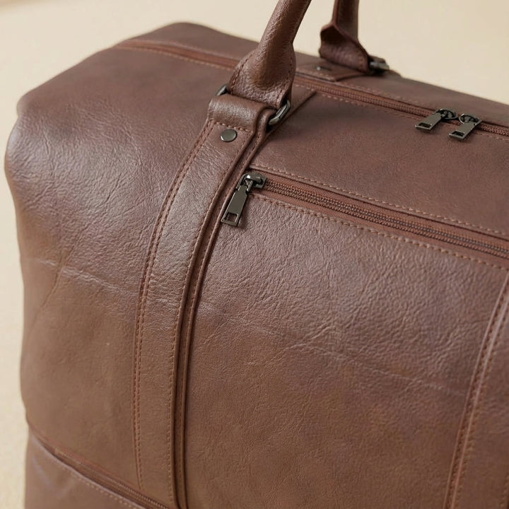 Unisex zwarte leren schoudertas als praktische duffelbag, ideaal voor weekendreizen en stijlvol.