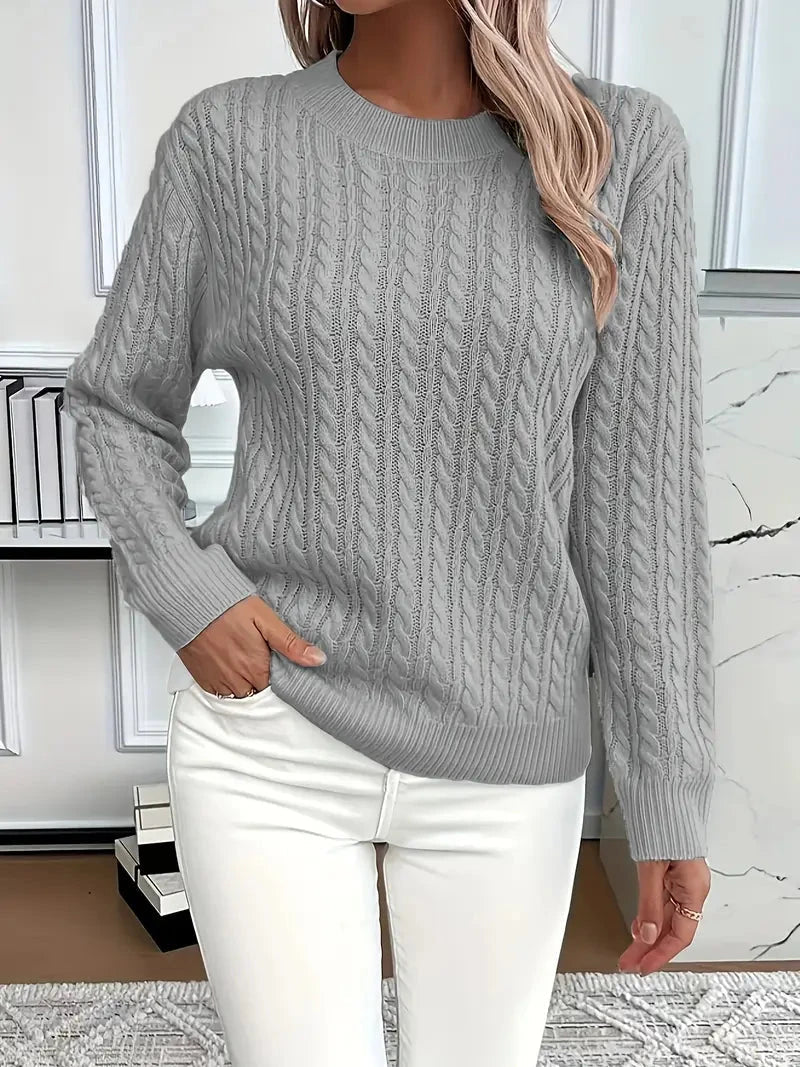 Model draagt modieuze dames kabeltrui met ronde hals, ideaal voor een casual én elegante winter look.