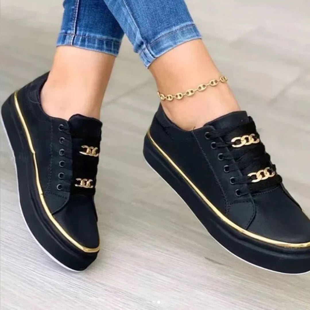 "Stijlvolle dames sneakers met gouden accenten, wit en zwart ontwerp. Chique en comfortabel voor elke gelegenheid."