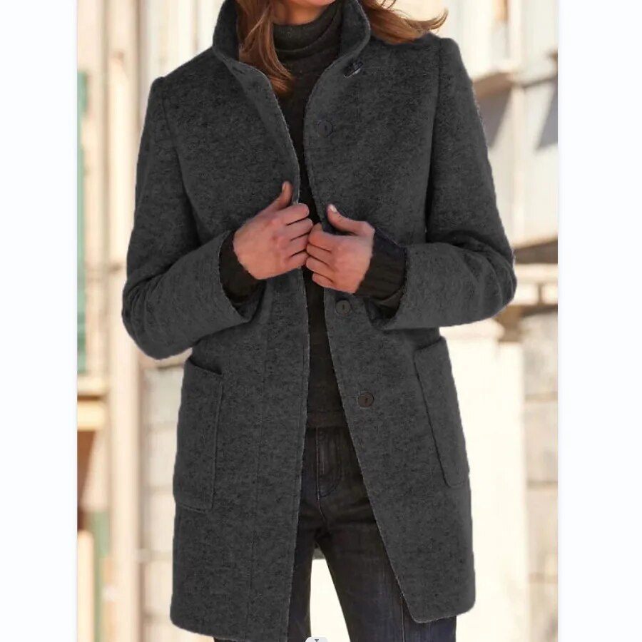 Detailopname van de opstaande kraag en knoopsluiting van deze comfortabele dames winterjas.