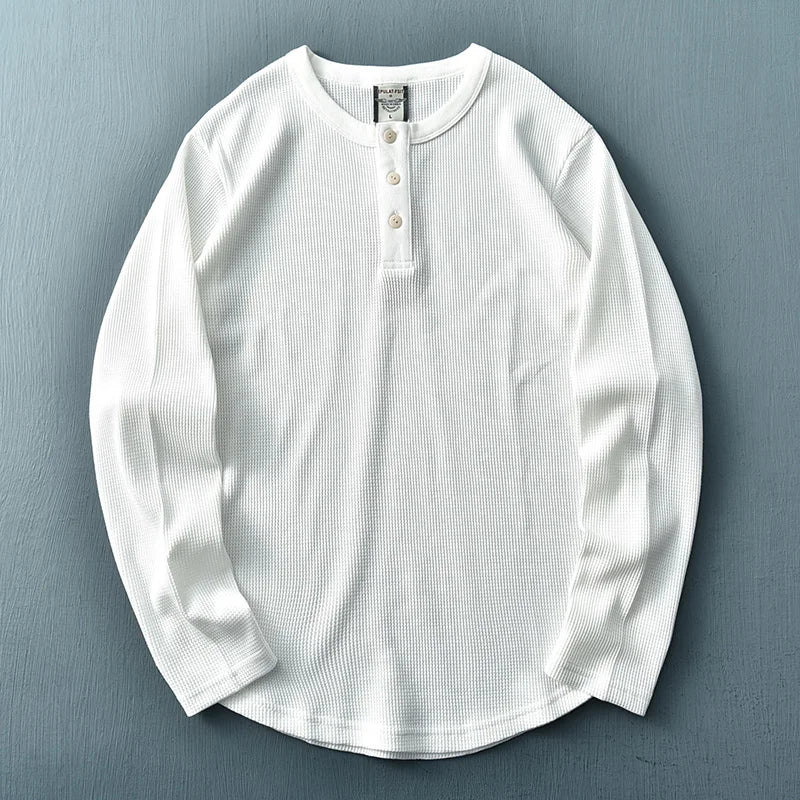 Detailopname van de knoopsluiting en kraag van een trendy herenkleding t-shirt.