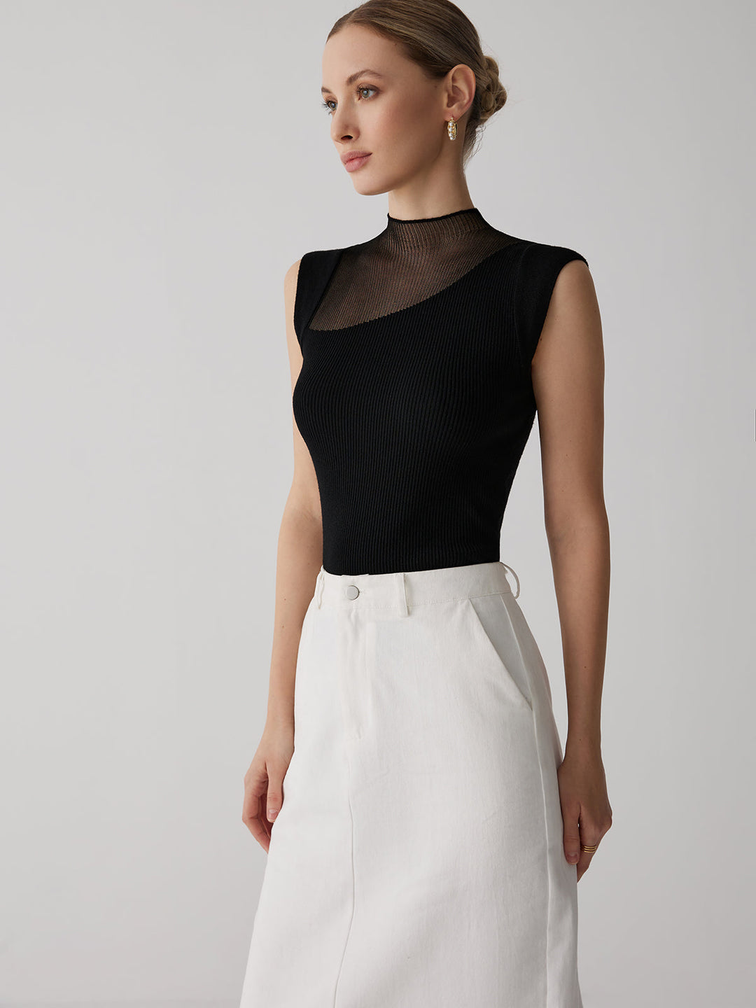 Zijaanzicht van het elegante zwarte damesshirt met transparante halsdetails