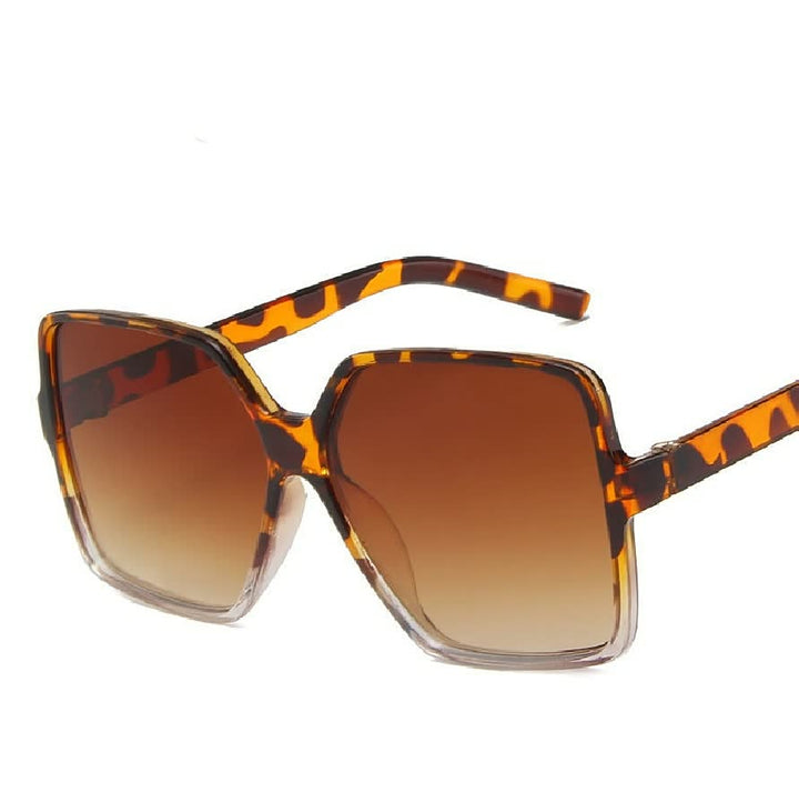 Modieuze grote dames zonnebril met opvallende gekleurde glazen, perfect voor een trendy zomerlook.