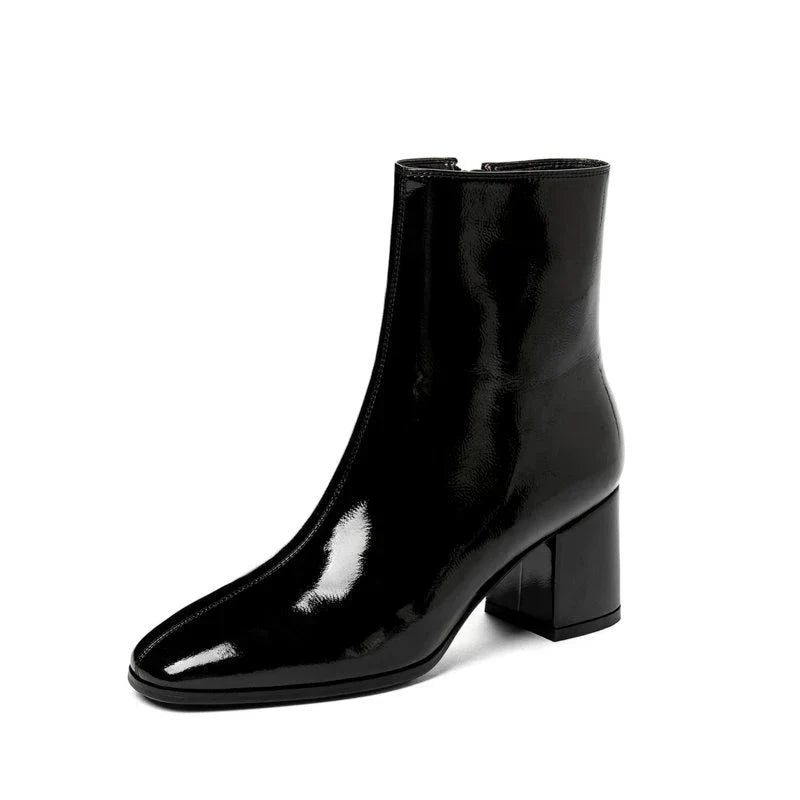 Detail van glanzende zwarte lak leren dames enkellaarzen. Trendy en chic, met comfortabele pasvorm voor dagelijks gebruik.