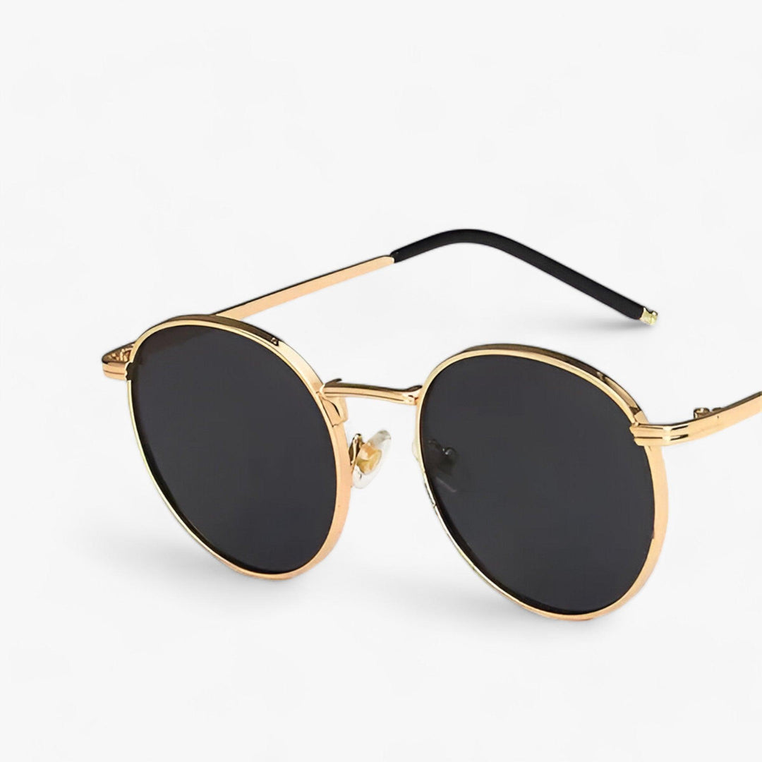 Uniseks zonnebril met ronde glazen en stijlvol metalen frame, biedt uv-bescherming. Trendy voor dames en heren.