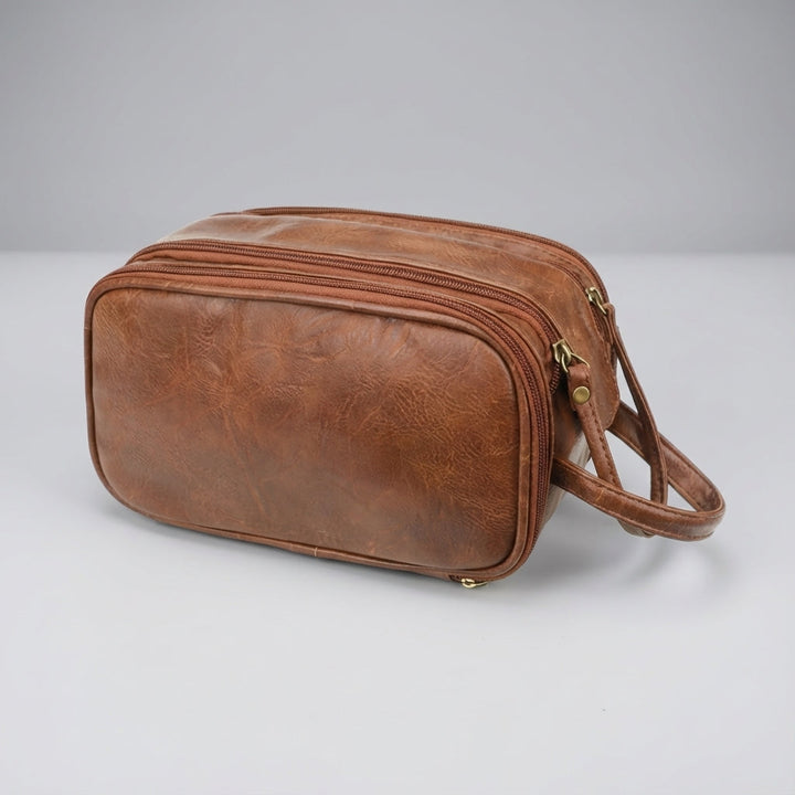 Bruine unisex reistoilettas, waterbestendig met meerdere vakken, perfect voor het compact opbergen van badkameressentials.