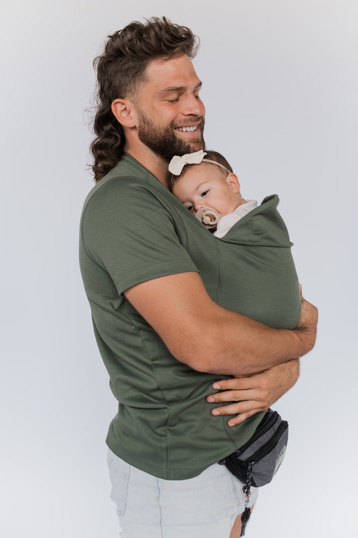 Gelukkige ouder met baby in flexibel draagshirt; optimale bewegingsvrijheid.