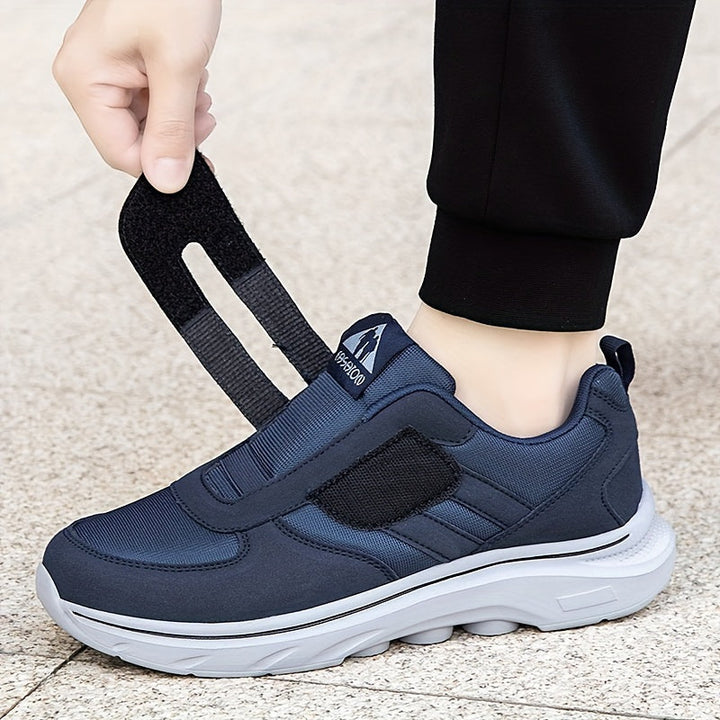 Zijaanzicht van de zwarte EasyStride loopschoen, met klittenband en comfortabele zool.