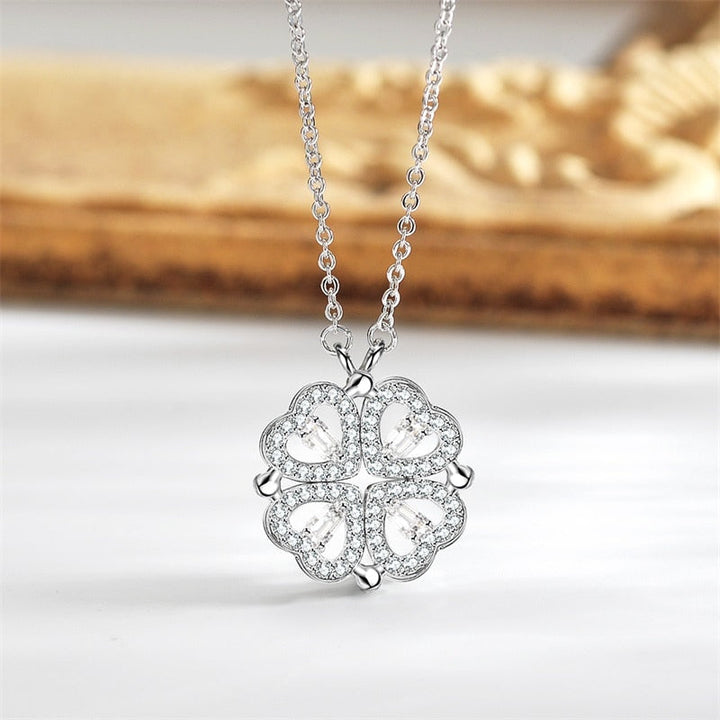 Close-up van een glanzende zilveren klavertje vier hanger aan een delicate ketting. Perfect gelukssymbool.
