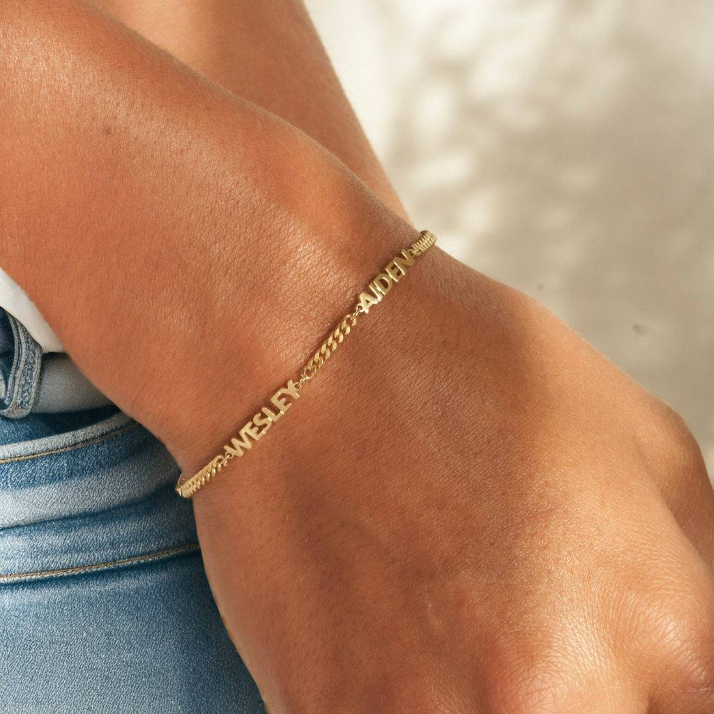 Unisex naamarmband met persoonlijke gravure, verkrijgbaar in goud of zilver, perfect als uniek geschenk.