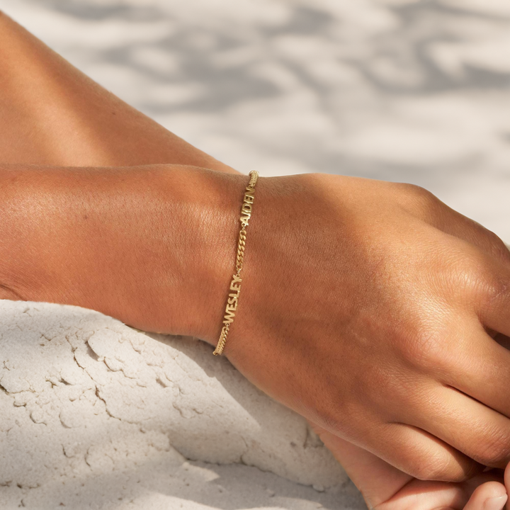 Unisex naamarmband met persoonlijke gravering, gedragen om de pols, in glanzend zilver, een uniek geschenk.