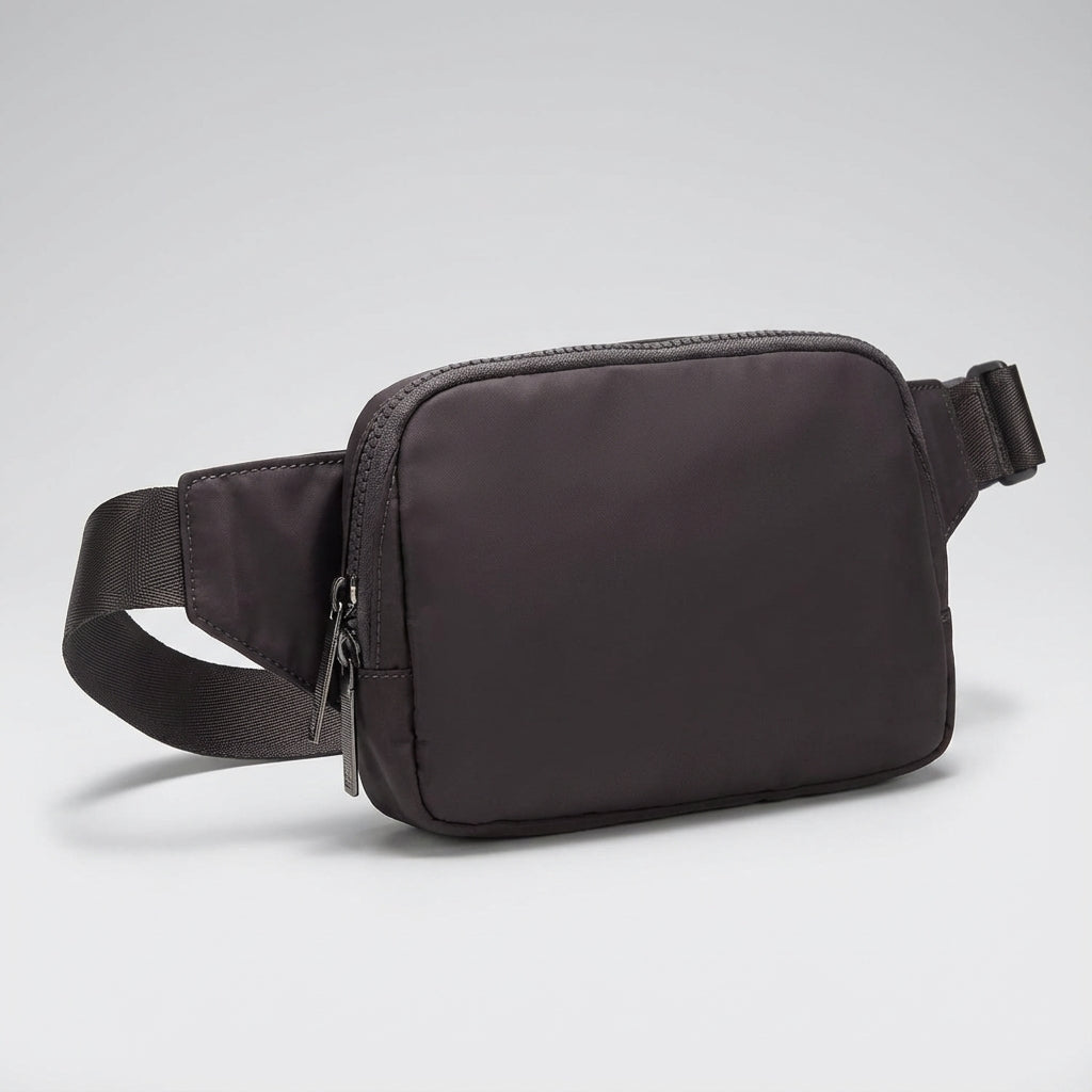 Veelzijdige nylon heuptas gedragen als crossbody tas, met ruime opbergruimte voor essentiële spullen.