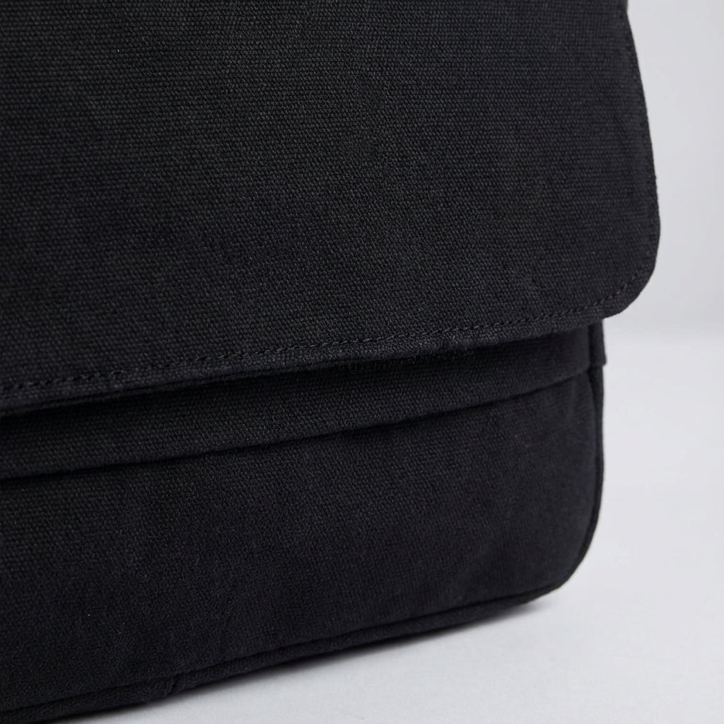 Close-up van de stevige canvas textuur van de unisex schoudertas, duurzaam en robuust, perfect voor dagelijks gebruik.