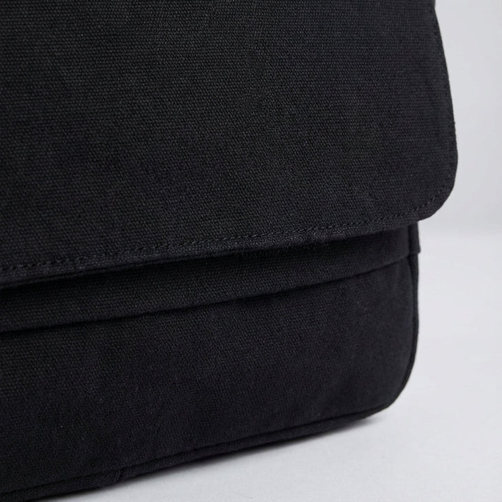 Close-up van de stevige canvas textuur van de unisex schoudertas, duurzaam en robuust, perfect voor dagelijks gebruik.